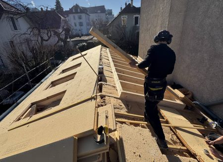 Couvreur posant une toiture en bois sur chantier à Annecy